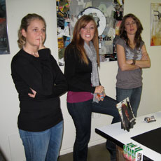 Three female students standing in an art classroom.